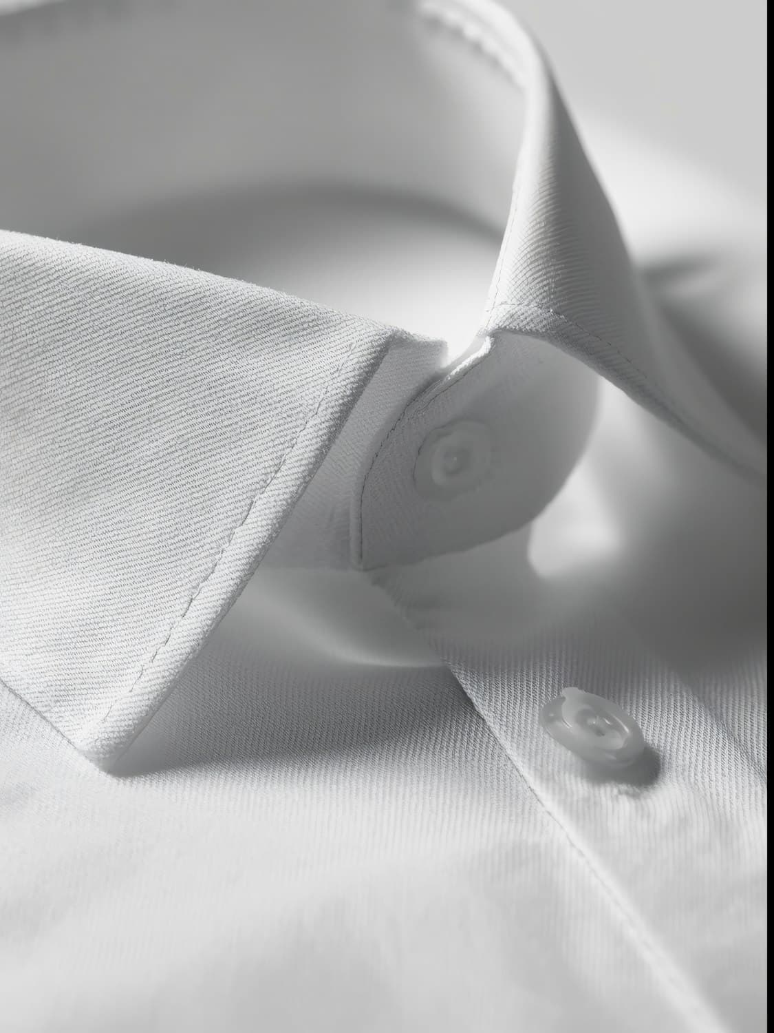 Detalhe da gola de uma camisa branca sob luz suave